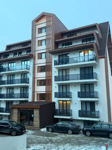 a building with two cars parked in front of it at Black Elegant & Spa Kop in Kopaonik