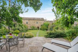 a patio with a table and chairs in a garden at 3 Bed in Askrigg oc-ds779 in Askrigg
