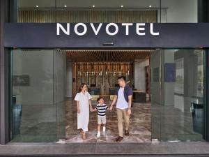 a family walking out of a novouc building at Novotel Bangkok Future Park Rangsit in Bangkok