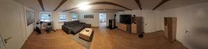 a living room with a couch and a tv at Am Fuße des Zoller in Bisingen