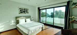 a bedroom with a bed and a large window at Exceptional villa in Vila Franca Do Campo with private pool in Vila Franca do Campo