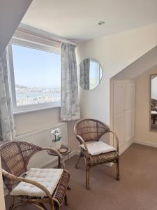 a living room with two chairs and a window at Broadlands View in Shaldon