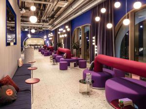a room with purple couches and tables and lights at ibis Styles Muenchen Perlach in Munich