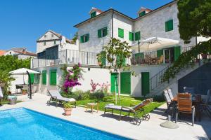 a house with a swimming pool next to a building at Villa Celine in Postira