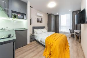 a bedroom with a bed with a yellow blanket on it at Видові Апарти на Озеро поруч з метро Позняки Харківська Ревуцького in Kyiv