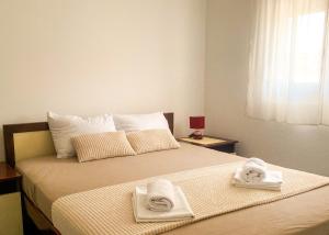 a bedroom with a bed with towels on it at VERIGE VIEW Kamenari in Donja Jošica