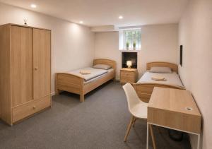 a bedroom with two beds and a desk and a table at Ermar Gästehaus in Baden-Baden +15 photos