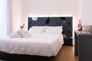 a bedroom with a large white bed with a black headboard at DB Residence Luxury Stay in Noventa di Piave