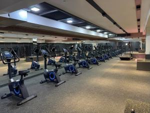 a gym with rows of treadmills and elliptical machines at Chotqol Sanatorium in G‘azalkent