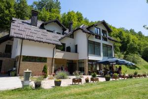 a large white house with people sitting outside of it at Zlatarska dolina in Nova Varoš