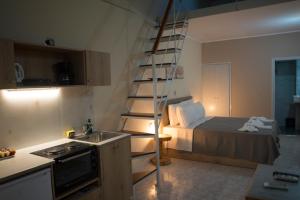 a kitchen with a bed and a spiral staircase in a room at Ενοικιαζόμενα δωμάτια ΣΟΛΩΝΑΣ in Mytilene