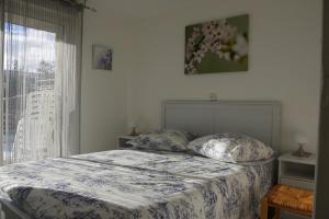 a bed with two pillows in a bedroom with a window at Gîte du Manival in Saint-Ismier