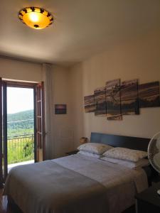 a bedroom with a large bed and a window at Appartamento Panoramico in Montepulciano
