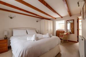 a bedroom with a large bed with white sheets at Mariners Cottage - Elie in Elie