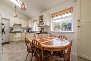 a kitchen with a wooden table and chairs at Mariners Cottage - Elie in Elie