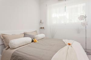 a white bedroom with a large bed with two pillows at The Apartment Trastevere - Ba.home in Rome