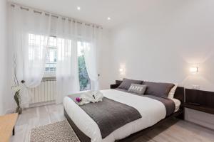 a white bedroom with a large bed and a window at The Apartment Trastevere - Ba.home in Rome
