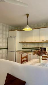 a kitchen with a table and a white refrigerator at Casa Laiglesia in Uncastillo