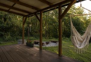 a porch with a hammock on a wooden deck at Maringotka MIMO in Uhelná +5 photos