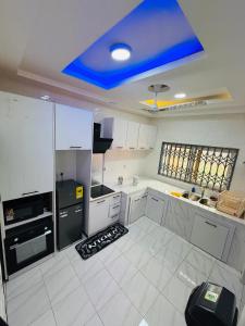 a large white kitchen with a blue ceiling at Pebview 2 Bed Apartment in Kpone