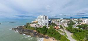 an aerial view of a beach and a tall building at Guarapari Center Aparts in Guarapari