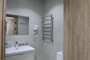 a bathroom with a sink and a toilet and a mirror at Chotqol Sanatorium in G‘azalkent +7 photos