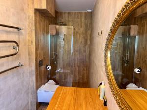a bathroom with a mirror and a sink at Arbatinės apartamentai in Biržai +70 photos