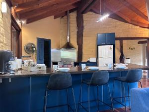 a kitchen with blue cabinets and a counter with stools at Moon light Retreat in Whittlesea