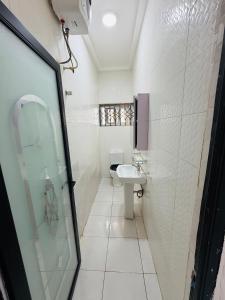 a white bathroom with a sink and a toilet at Pebview 2 Bed Apartment in Kpone +28 photos