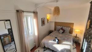 a small bedroom with a bed and a mirror at Maison de la Liberté - Petite maison à 4 étages in Nyons