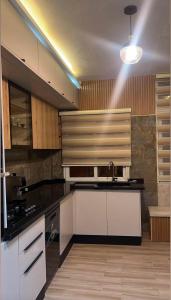 a kitchen with white cabinets and a black counter top at La perle de bizerte in Bizerte