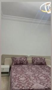 a bedroom with a bed with a purple blanket at La perle de bizerte in Bizerte