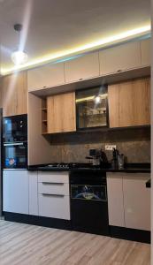 a kitchen with white and black appliances and wooden cabinets at La perle de bizerte in Bizerte +14 photos