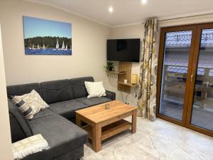 a living room with a couch and a coffee table at Apartamenty Szwagra Augustów in Augustów
