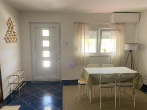 a dining room with a white table and chairs at VERIGE VIEW Kamenari in Donja Jošica