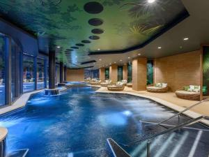 a large swimming pool in a hotel lobby at Minaro Hotel Tokaj - MGallery Collection - Adults Only in Tokaj