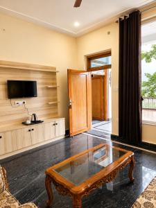 a living room with a coffee table and a tv at The Palace by Boho Travelista in Bhīm Tāl