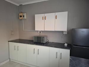 a kitchen with white cabinets and a microwave at Phola La Bed and Breakfast in Melmoth +67 photos