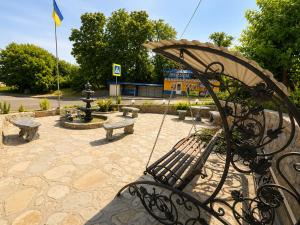 a park with benches and a fountain and a flag at Family ЛюКс in Kamianets-Podilskyi