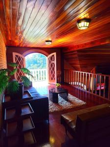 a living room with a couch and a large window at Refugio maná in Campos do Jordão