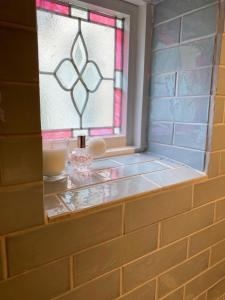 a window in a bathroom with a candle on a shelf at Collingwood House Tynemouth in Tynemouth +22 photos