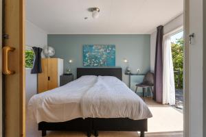 a bedroom with a bed and a window at Luwte aan het Lauwersmeer, Friesland in Anjum