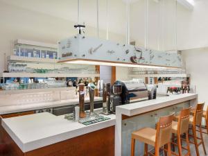 a restaurant with a bar with chairs and a counter at Mercure Szekesfehervar Magyar Kiraly in Székesfehérvár