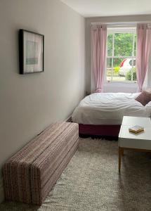 a bedroom with a bed and a window and a couch at Collingwood House Tynemouth in Tynemouth