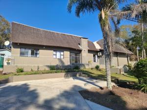 a house with a palm tree in front of it at Phola La Bed and Breakfast in Melmoth