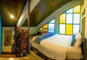 a bedroom with a large bed with stained glass windows at Omah Njonja Bed & Brasserie in Yogyakarta +53 photos