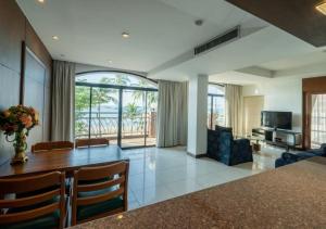 a dining room and living room with a table and chairs at Baywalk Residence Pattaya in Pattaya