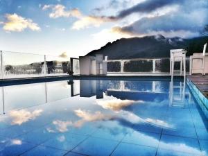 a swimming pool with two chairs and a mountain at Jacky's Guesthouse in Yuanyang