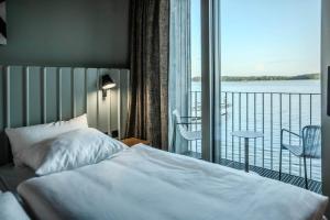 a bedroom with a bed and a balcony with a view at Im-Jaich Naturoase Gustow in Gustow