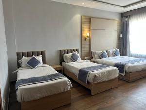 a hotel room with two beds and a window at Sshubh Hotel Nathdwara in Nāthdwāra +92 photos